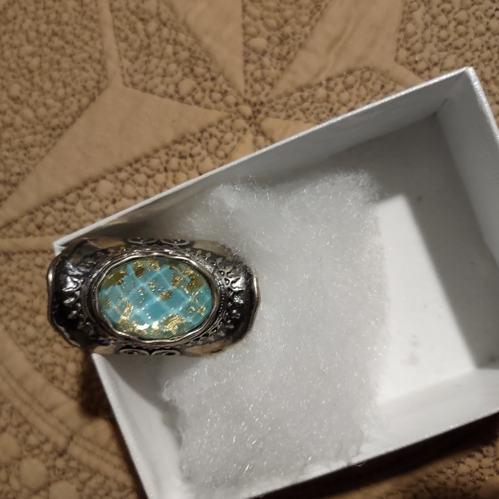 Silver ring with blue stone, flecks of gold. No Hallmark. Priced accordingly.